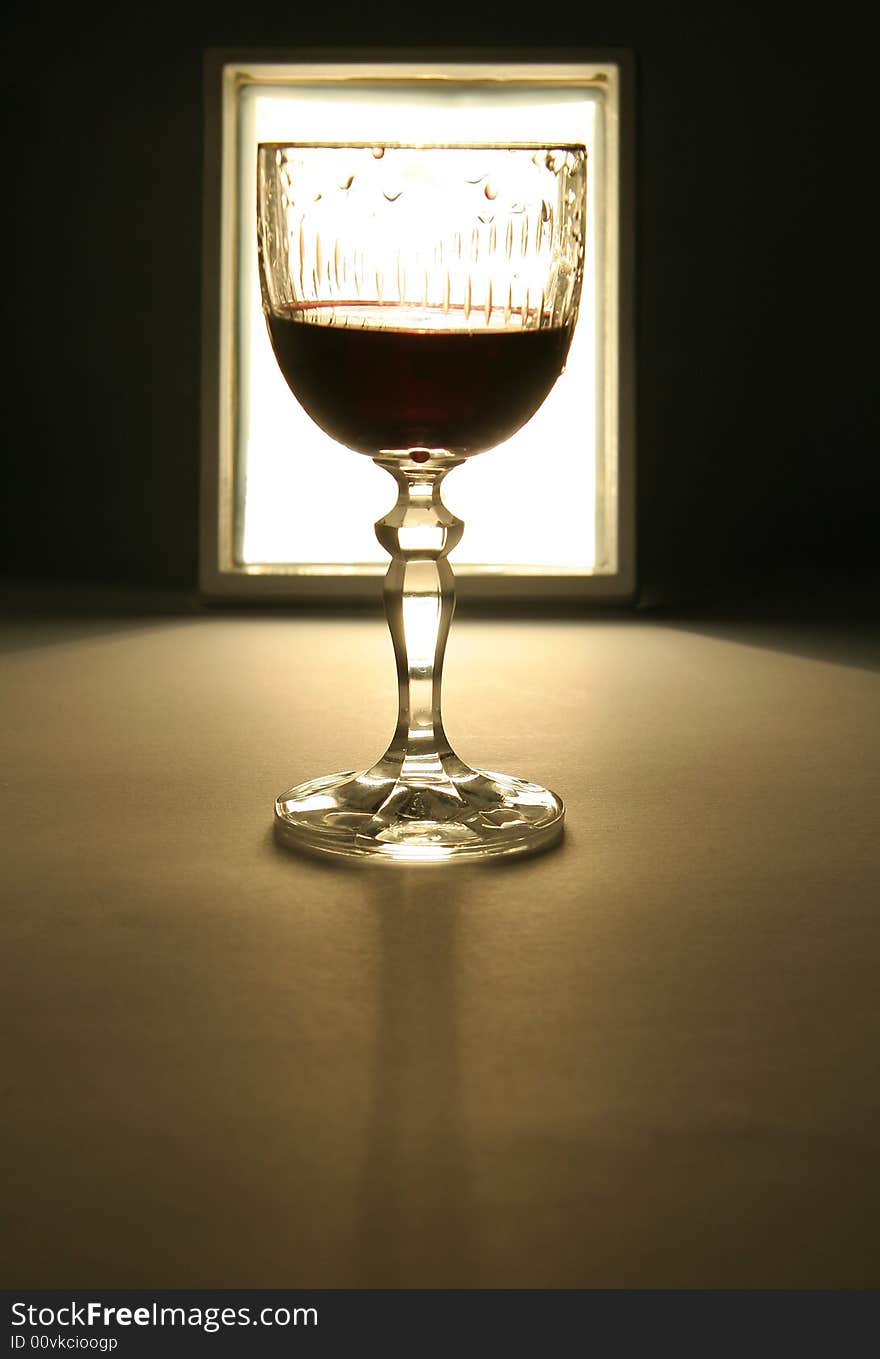 Glass of wine silhouette, white light in background