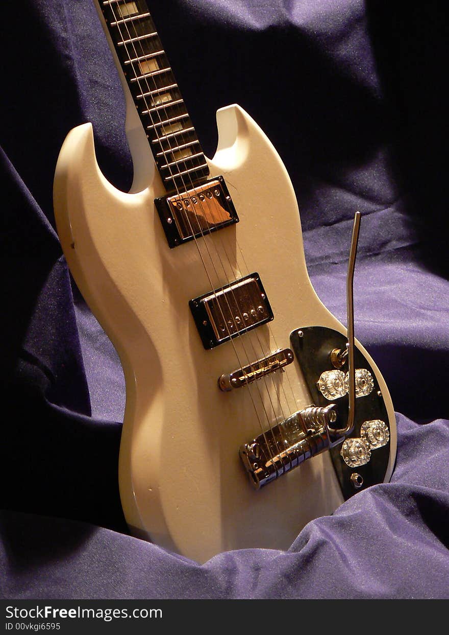 White electric guitar, low light