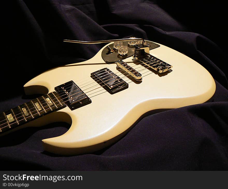 White electric guitar on dark background