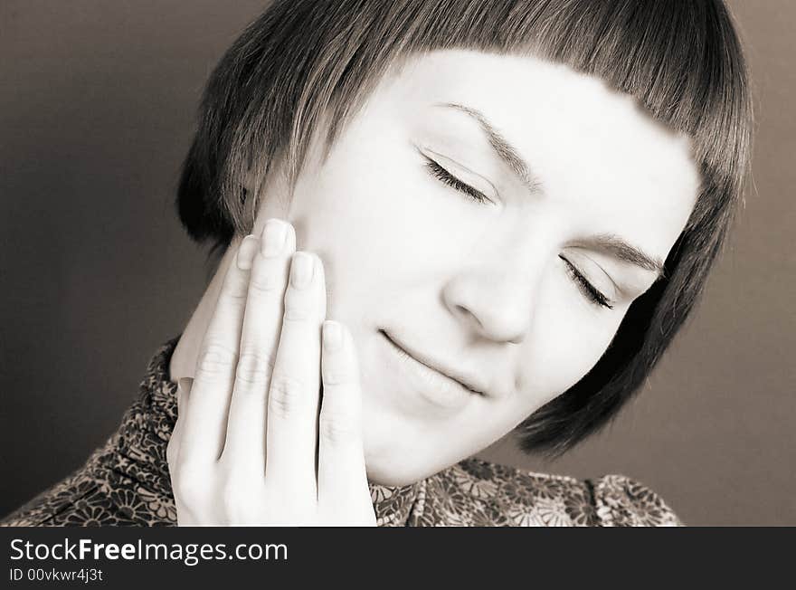 Beautiful woman touching her face, sepia toned