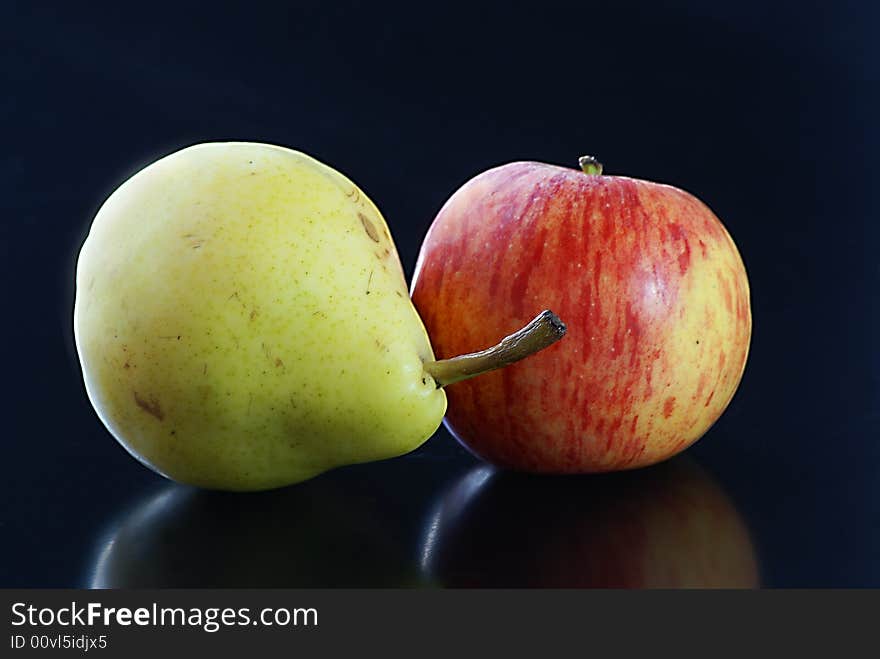 Close up of green pear and red apple on a black background. Close up of green pear and red apple on a black background