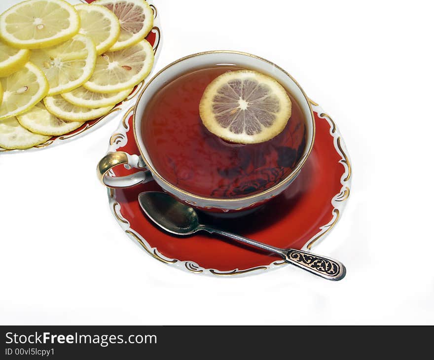 Ancient teacup with black tea and lemon