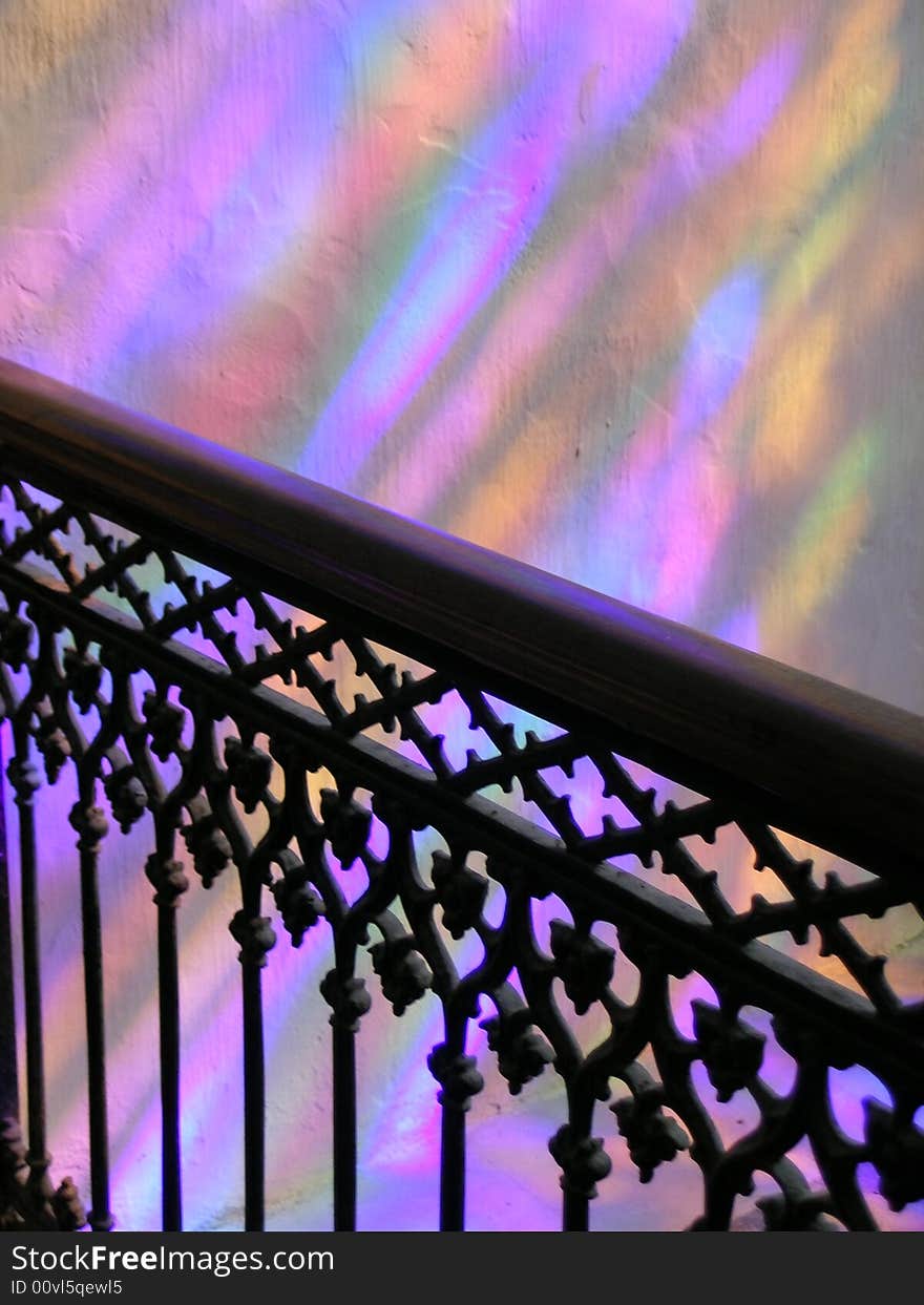 Colour light reflexes filtering from a stainglass window in a church creating a rainbow effect. Colour light reflexes filtering from a stainglass window in a church creating a rainbow effect.