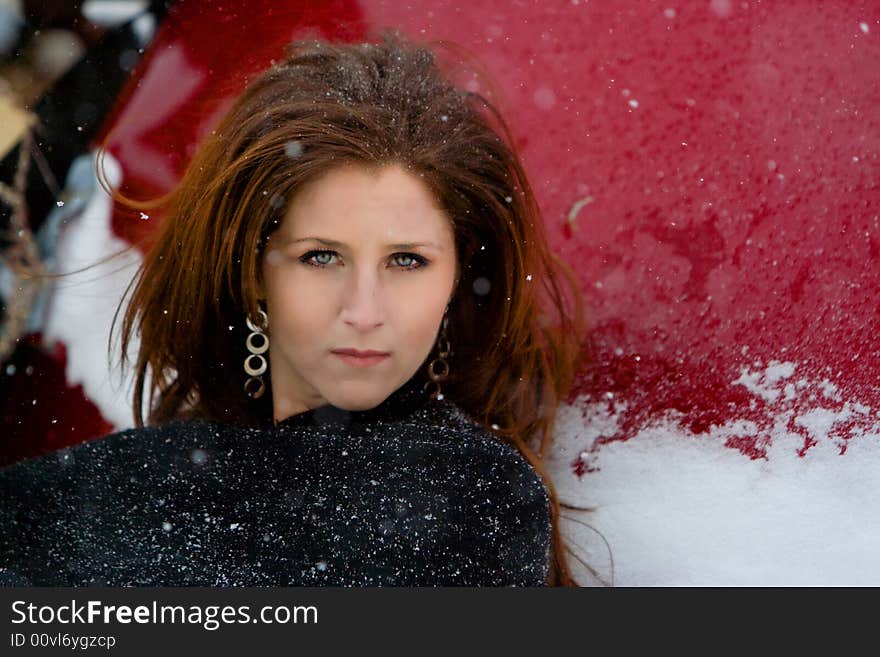 a girl sits amongst a junkyard in a blizzard. a girl sits amongst a junkyard in a blizzard