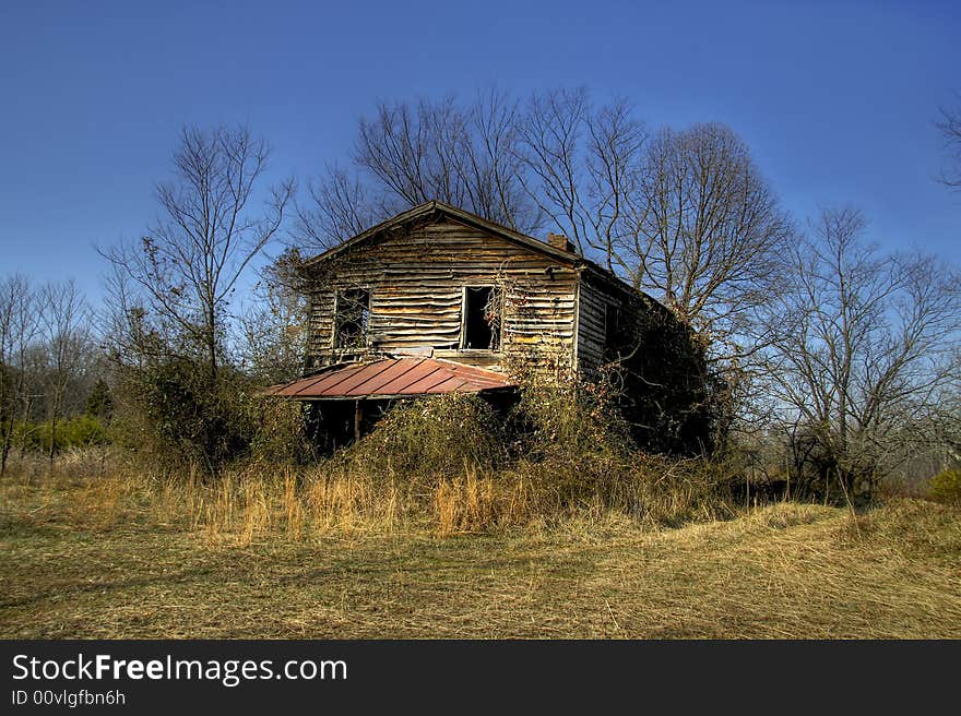 Old abandoned and rundown house sitting in the middle of a field. Old abandoned and rundown house sitting in the middle of a field.