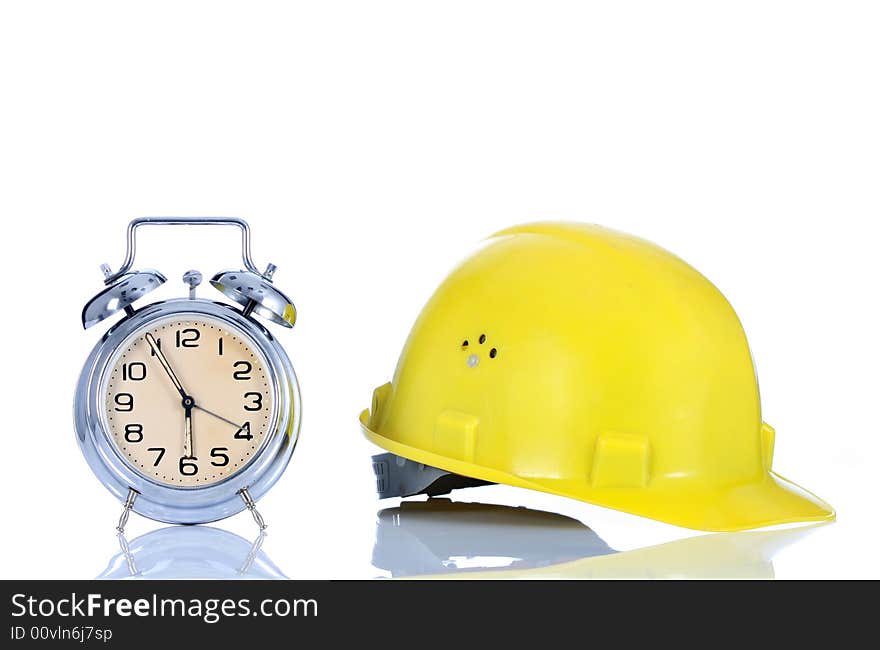 Alarm clock and helmet on white background