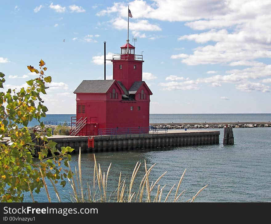 Bright red lighthouse at the entrance of the Holland Harbor. Bright red lighthouse at the entrance of the Holland Harbor.