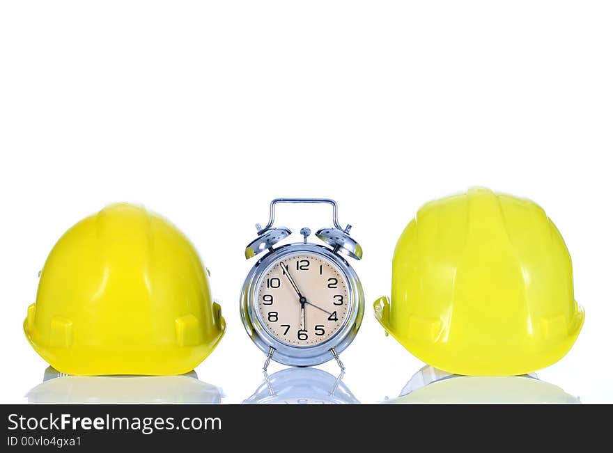 Alarm clock and helmet on white background