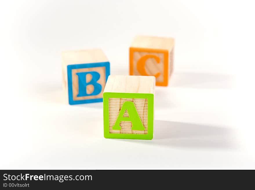 ABC blocks laying on a white surface. ABC blocks laying on a white surface