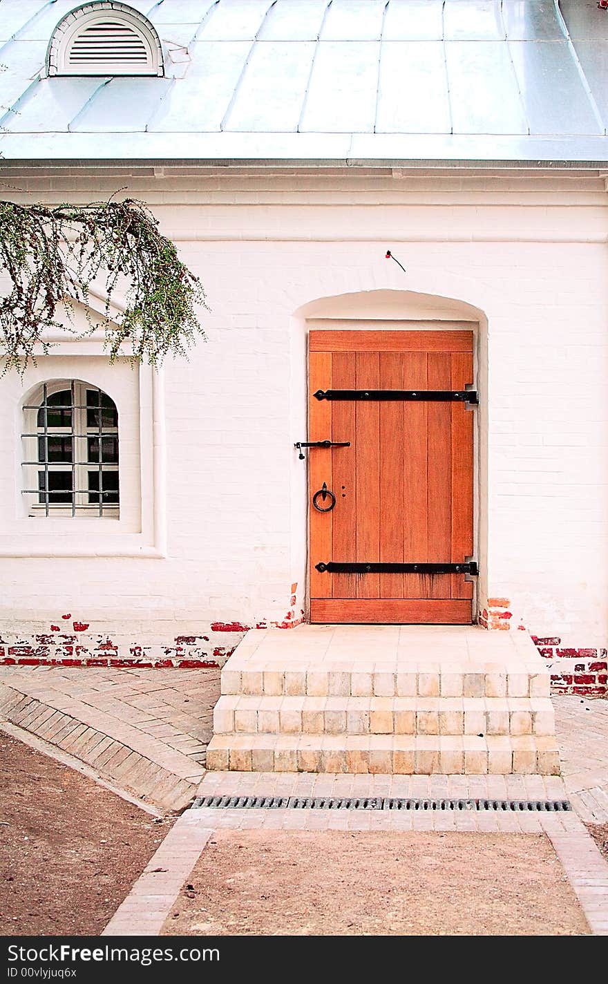 White small house with a wooden door.