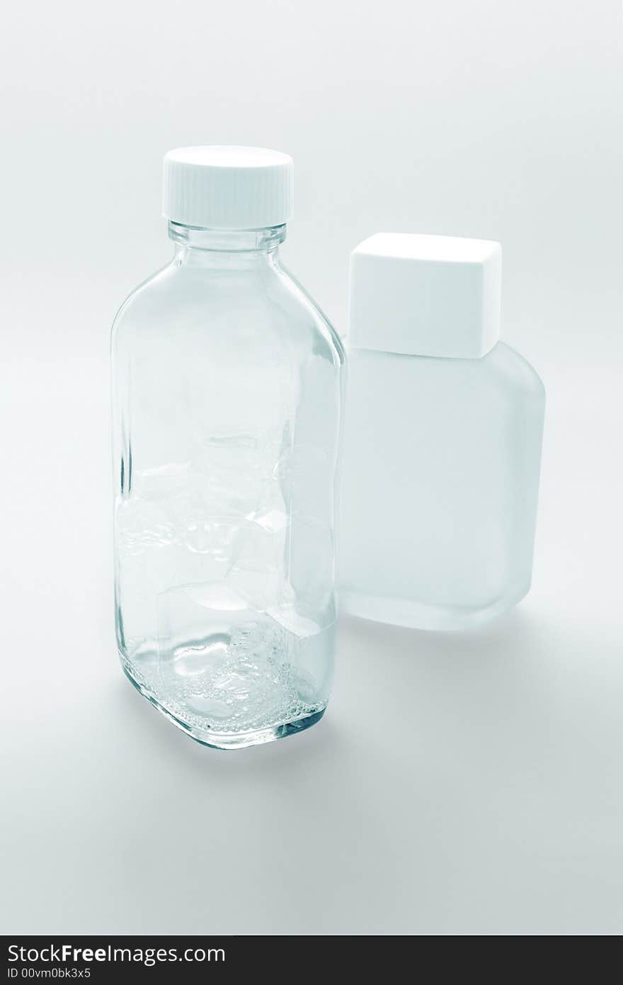 Two empty glass cosmetic containers on the white background. Two empty glass cosmetic containers on the white background