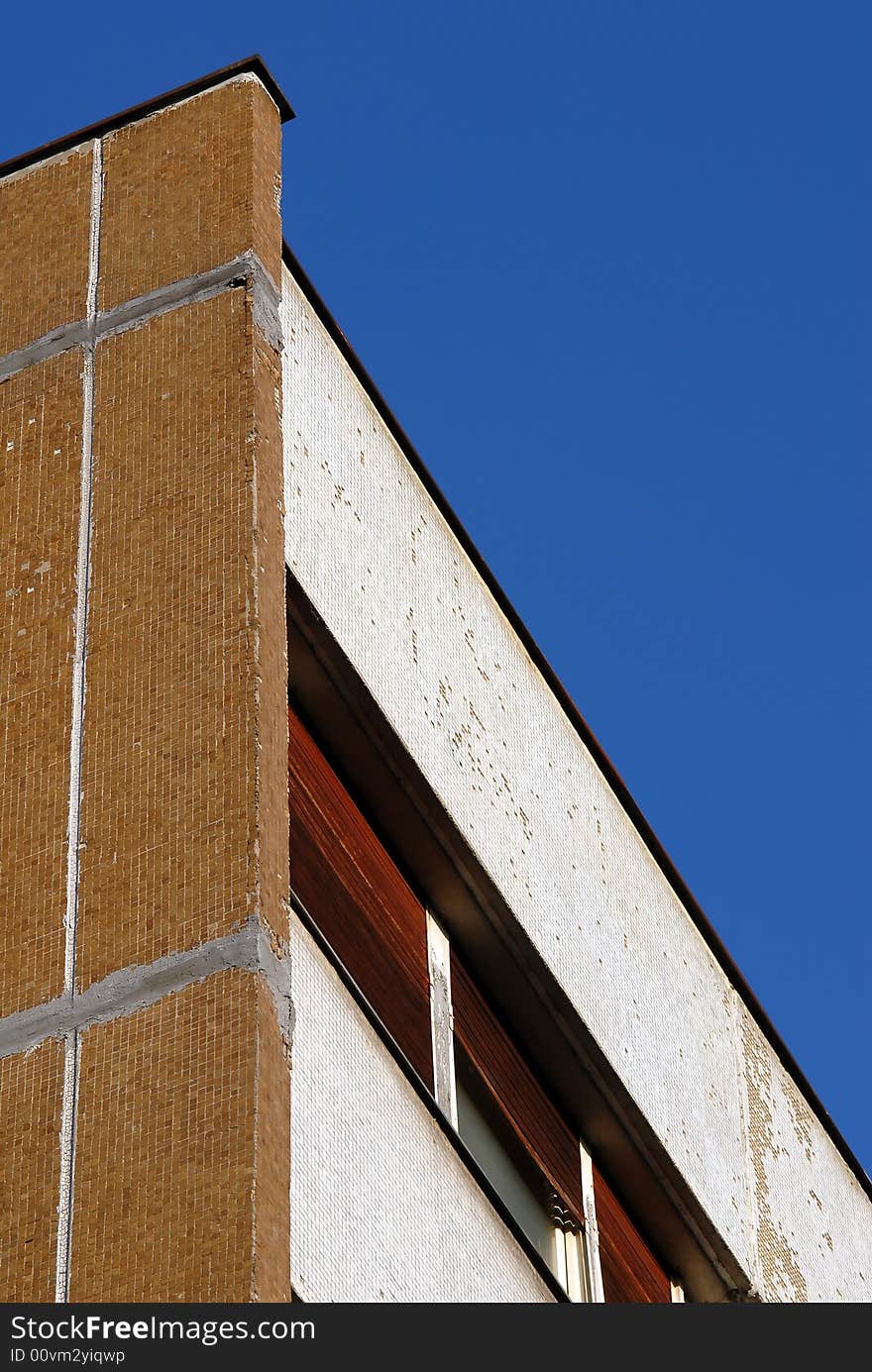 Close-up of urban building wall and windows isolated over blue sky