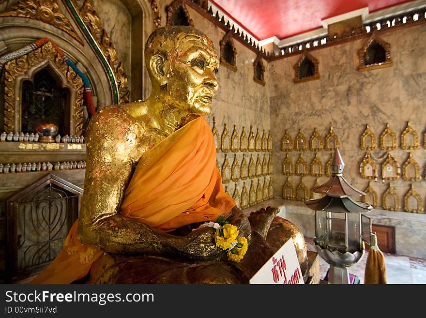 A seated buddha statue covered in gold leaf in a buddhist temple in Thailand. A seated buddha statue covered in gold leaf in a buddhist temple in Thailand.