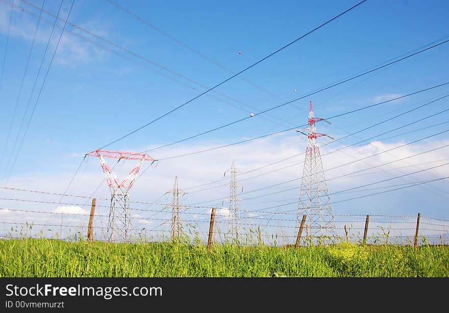 Electricity pylon and power cables over farmland in Italy