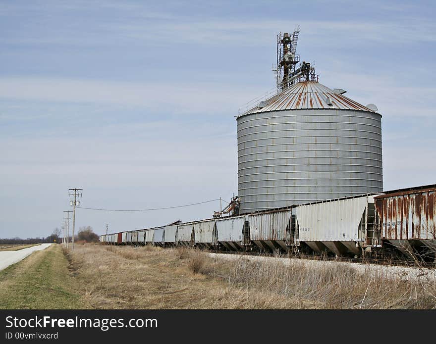 A series of grain cars being loaded with corn at a grain elevator in the midwest. A series of grain cars being loaded with corn at a grain elevator in the midwest