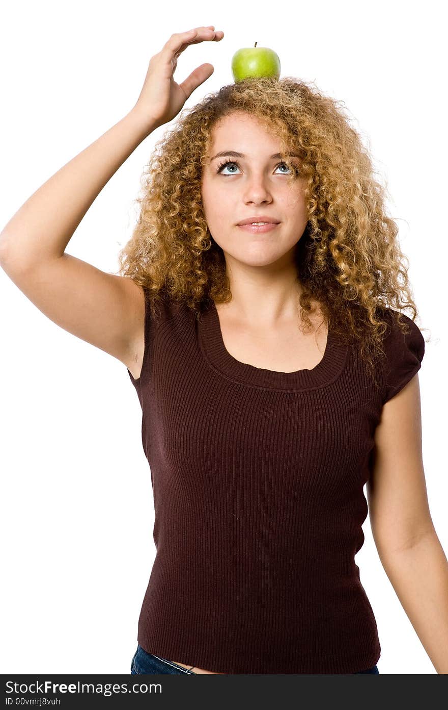 A young woman balancing a green apple on her head. A young woman balancing a green apple on her head