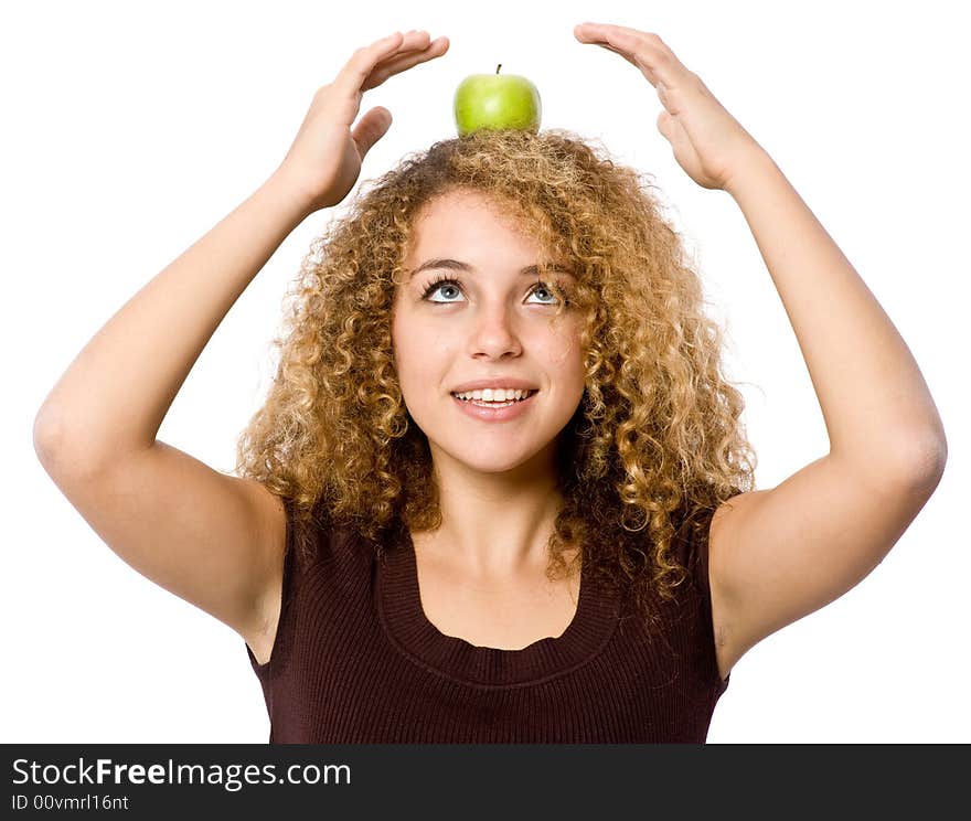 A young woman balancing a green apple on her head. A young woman balancing a green apple on her head