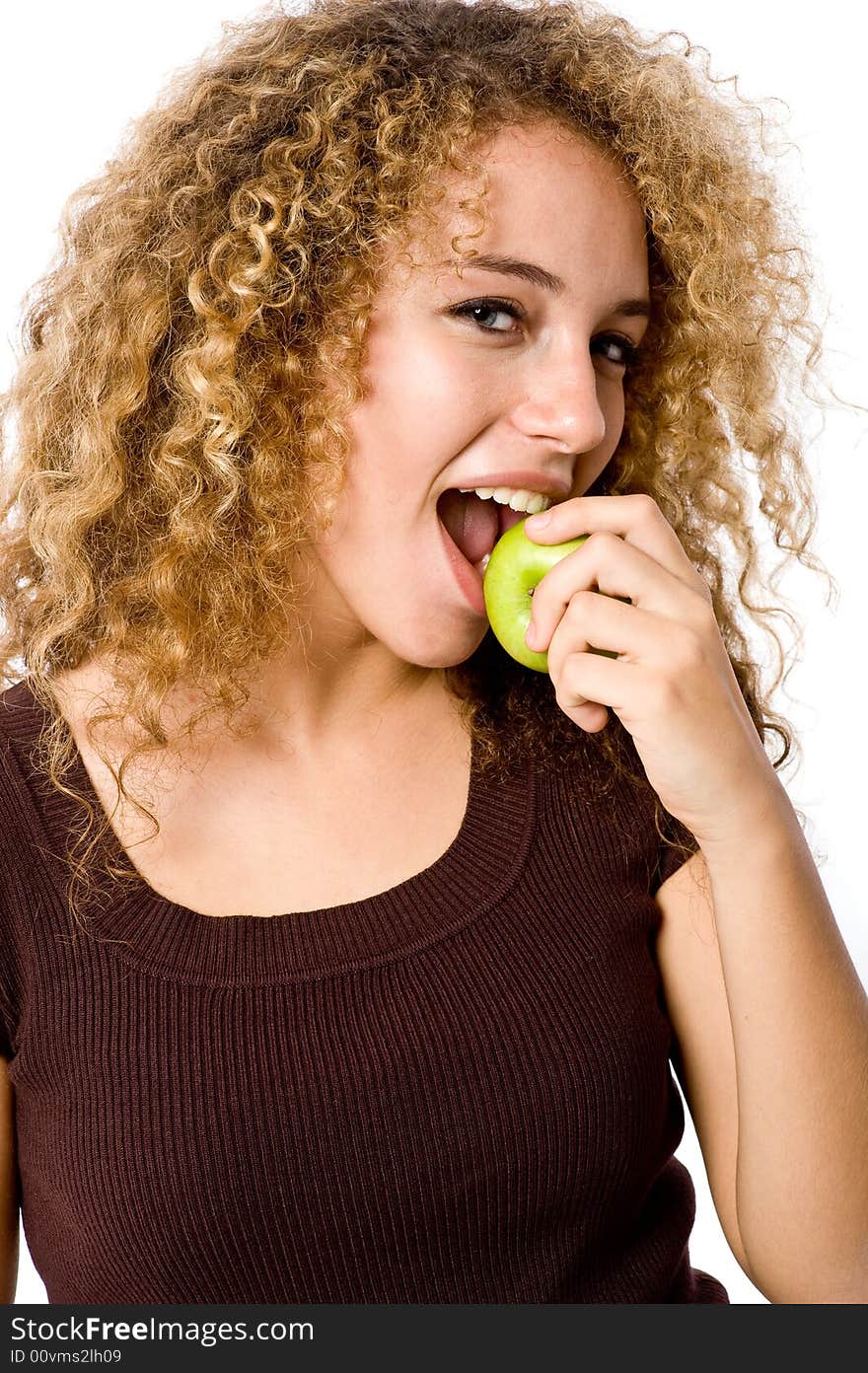 A pretty young woman holding an apple she's about to eat. A pretty young woman holding an apple she's about to eat