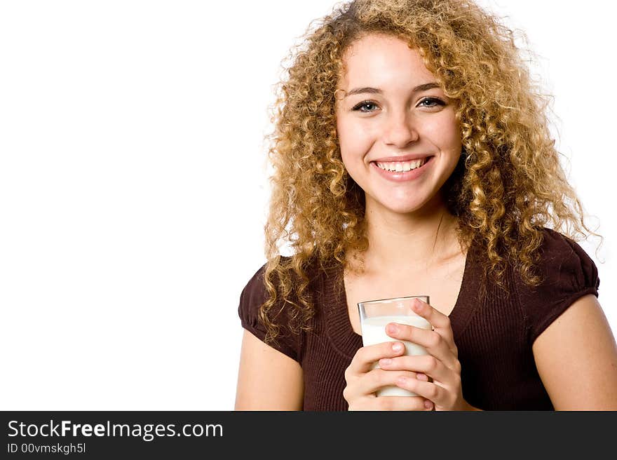 A pretty young woman holding a glass of milk. A pretty young woman holding a glass of milk