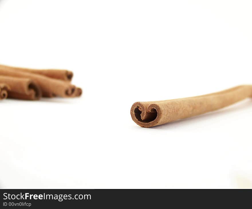 Horizontal image of a single cinnamon stick with others visible in the background. Horizontal image of a single cinnamon stick with others visible in the background.