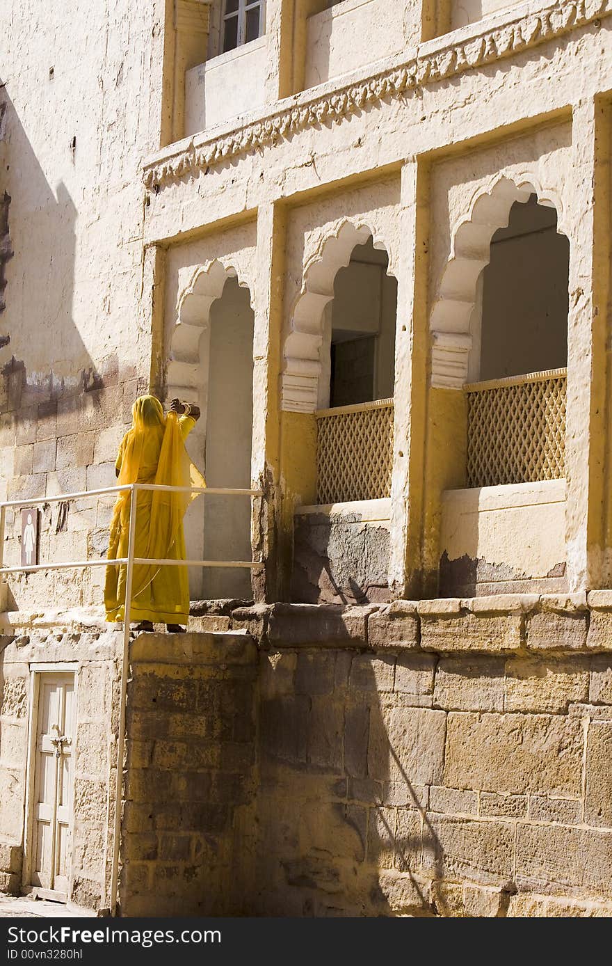 Hindu woman in yellow sari in front of a Rajastan temple. Hindu woman in yellow sari in front of a Rajastan temple