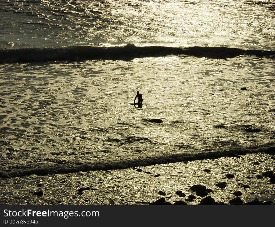 A lone surfer at sunset