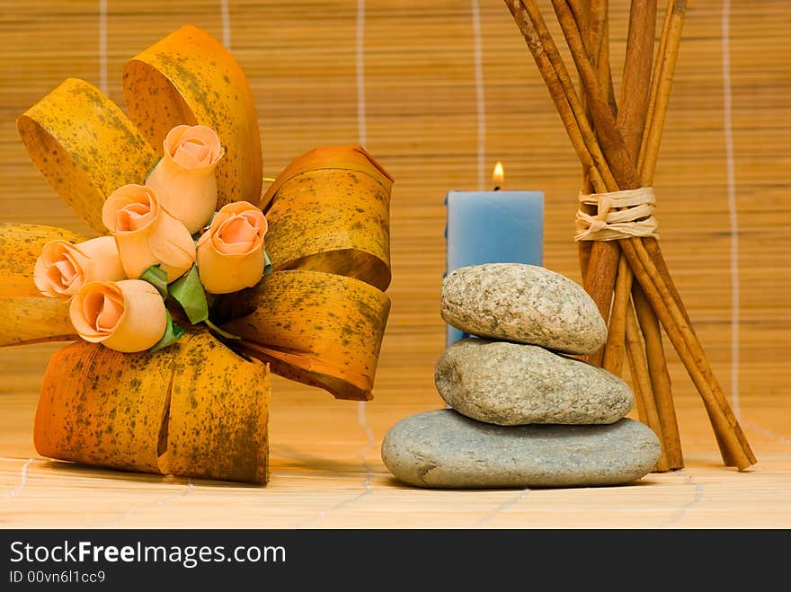 Still life with three round stone, cinnamon,rose and candle