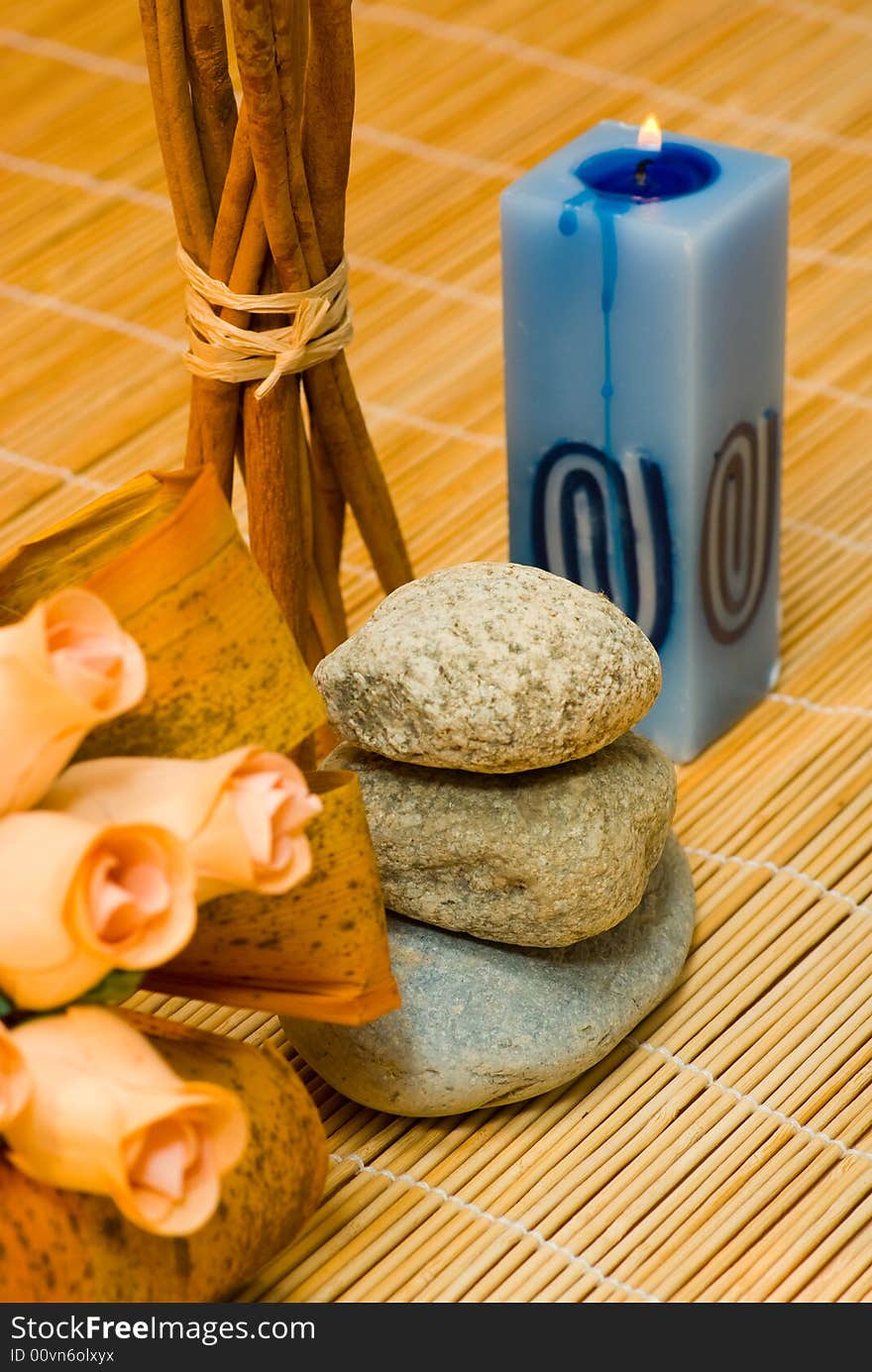 Still life with three round stone, cinnamon,rose and candle