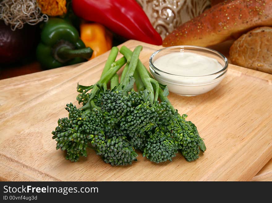 Fresh raw baby broccoli spears and ranch dressing in kitchen or restaurant.