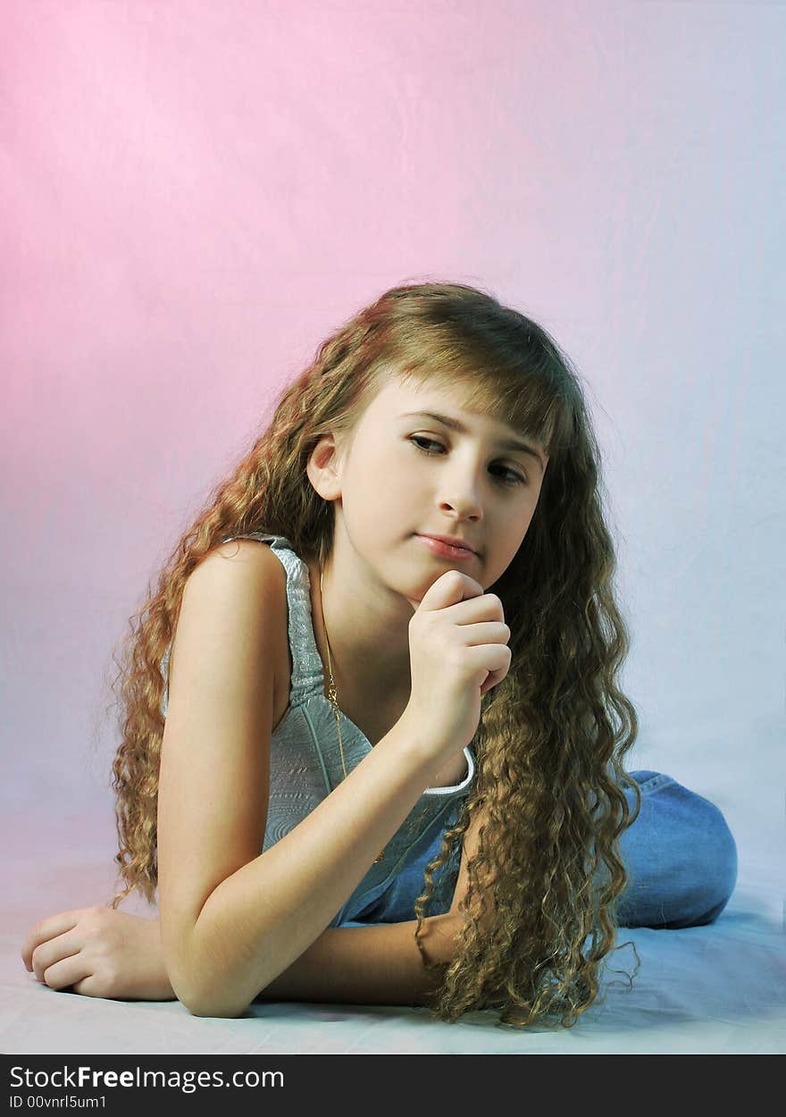 Girl with long and curly hair sits on floor. Girl with long and curly hair sits on floor