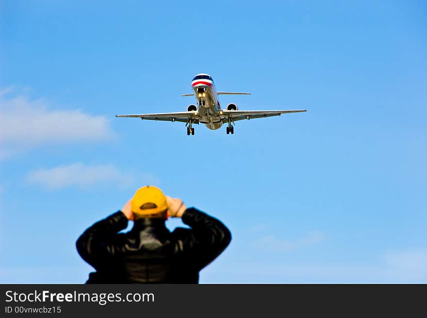 Aeroplane landing while an spectator looks on. Aeroplane landing while an spectator looks on