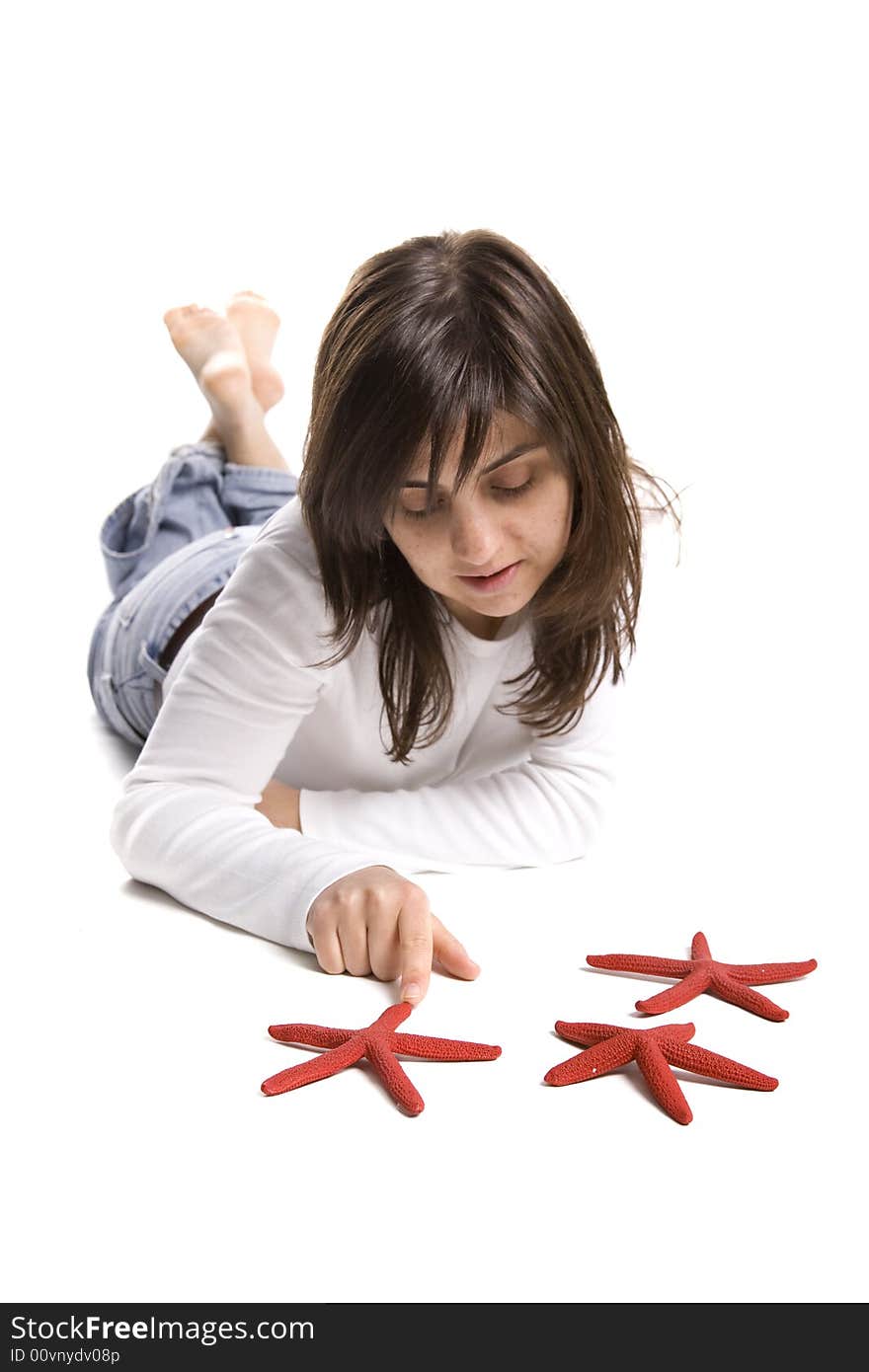 Young beautiful woman playing with red starfish isolated on white background