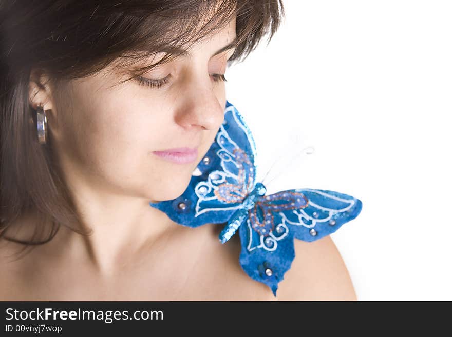 Beautiful young woman with blue butterfly in her naked shoulder - focus on the eye