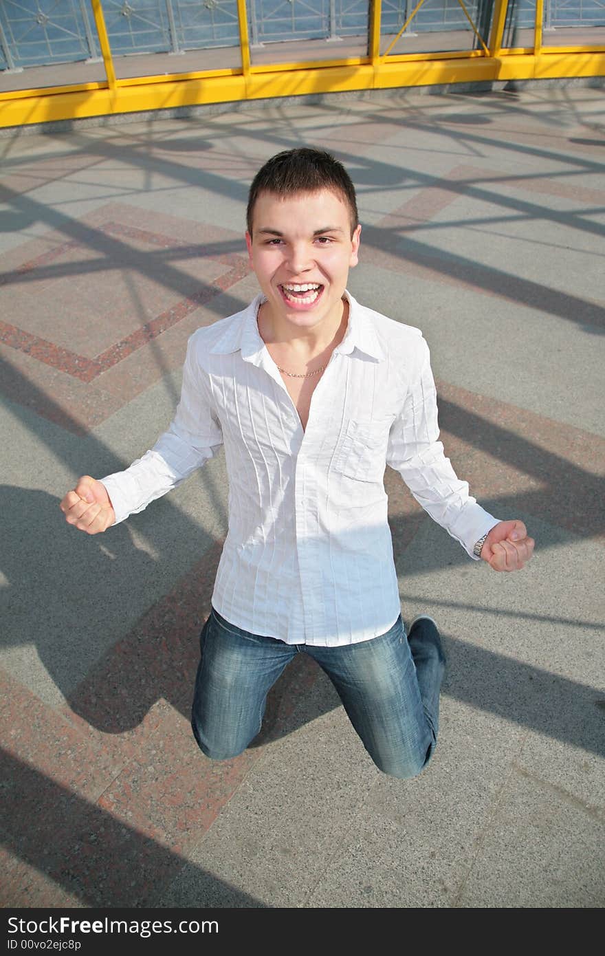 Young man stands on knees on the footbridge