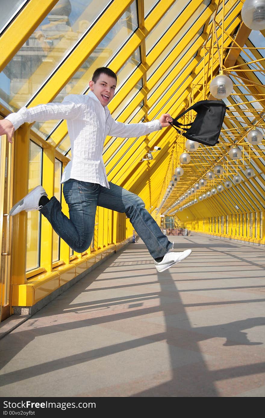 Young man jumps with bag on footbridge