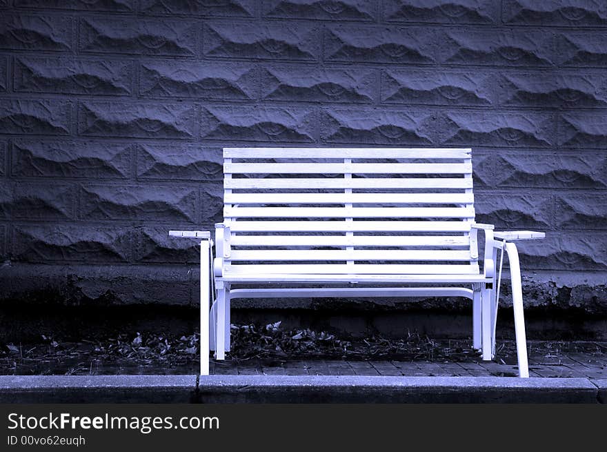 White park bench with gray brick background