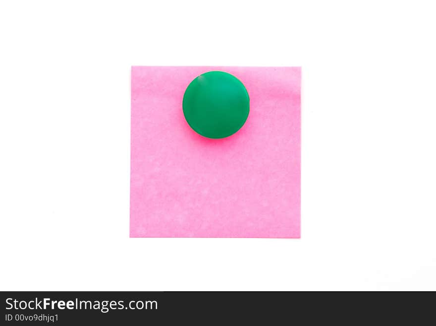 Red note with green magnet on white. Red note with green magnet on white