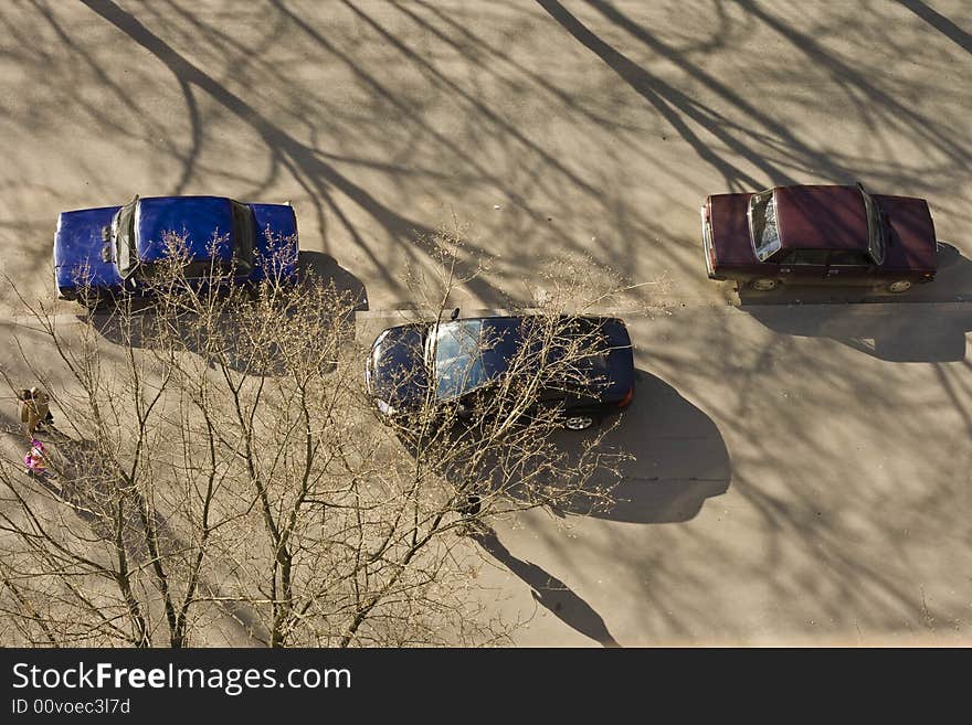 Three cars on the city street in a sun summer day