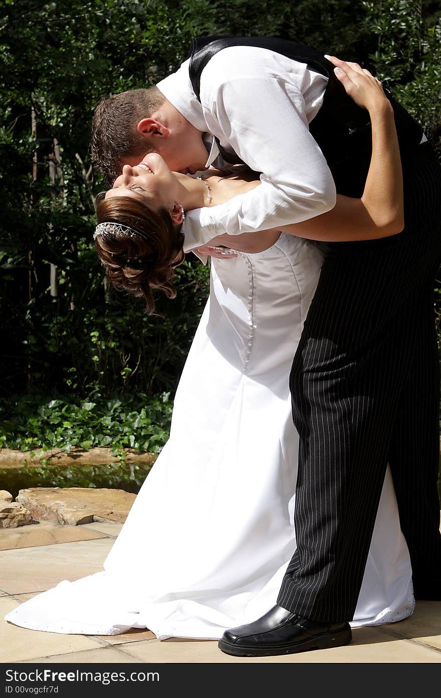 A groom kissing his bride in the neck. A groom kissing his bride in the neck