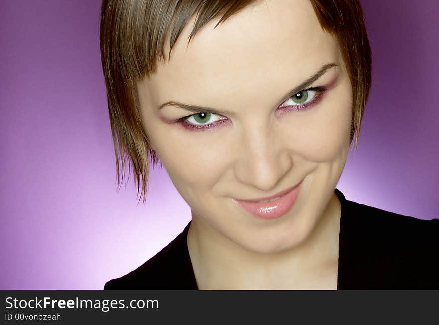 Beauty woman with green eyes on purple background, face close up