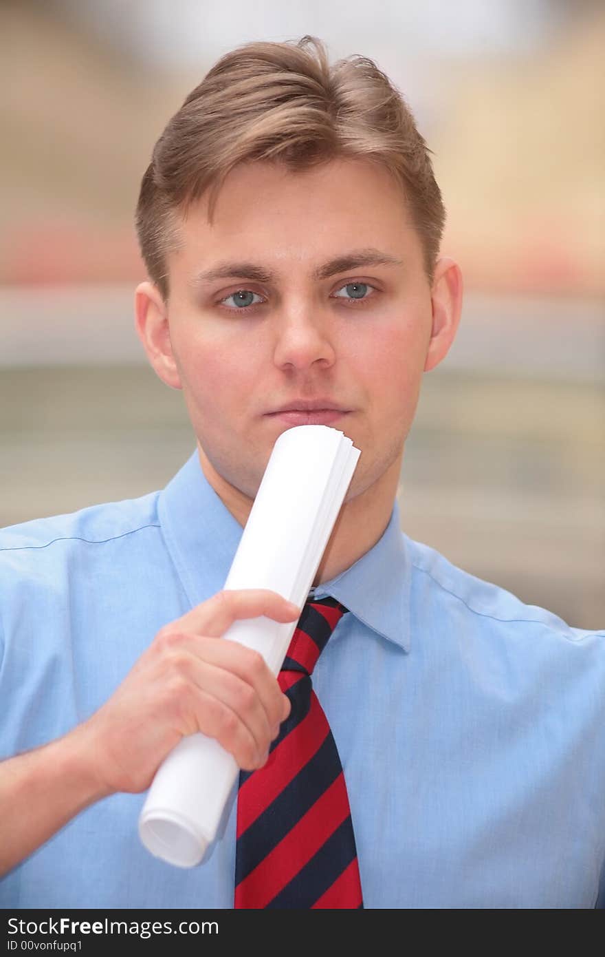 Young businessman with folded papers