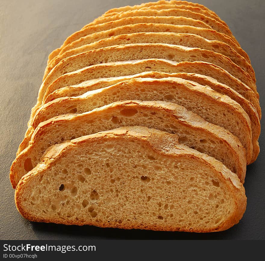 Large slices of crusty white bread on black background. Large slices of crusty white bread on black background