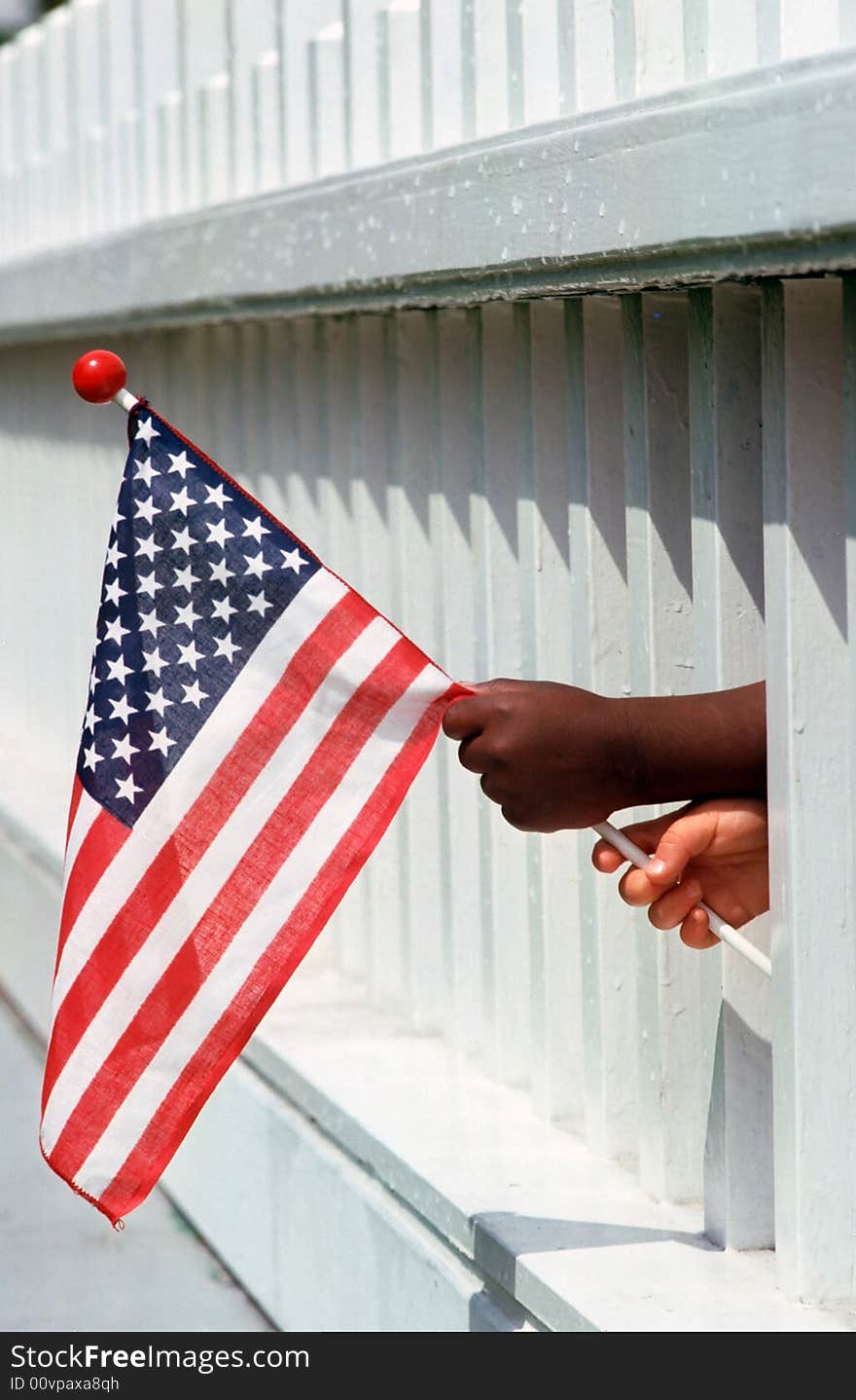 Two mixed race boys hold a flag together. Two mixed race boys hold a flag together