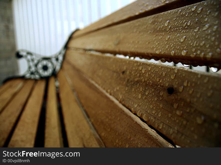 A wooden chair drenched the morning from the previous night's rain and the morning due. A wooden chair drenched the morning from the previous night's rain and the morning due.