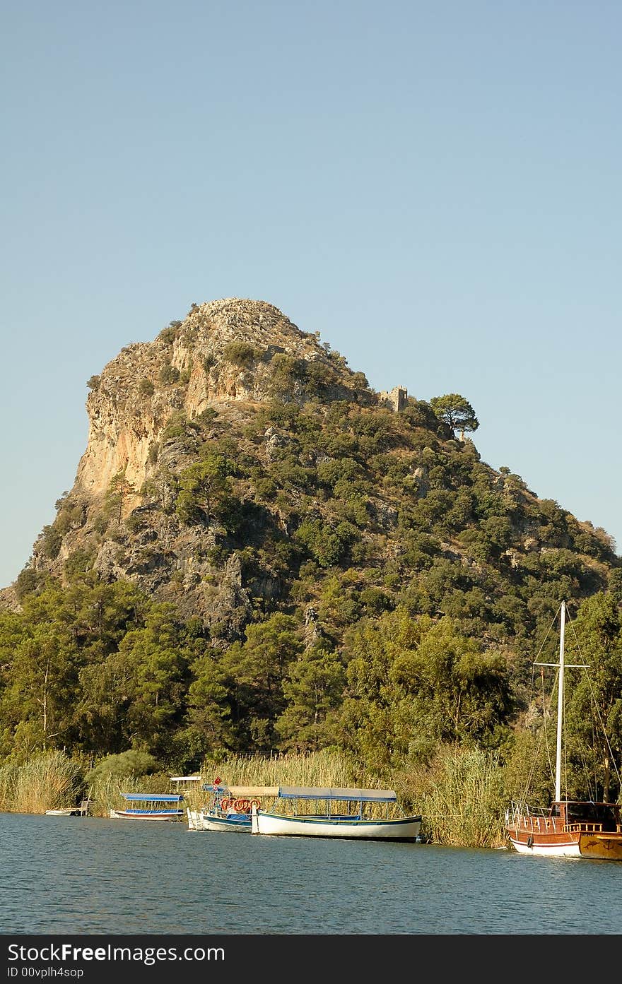 Three fishing boats and one small yacht near a rock. Three fishing boats and one small yacht near a rock