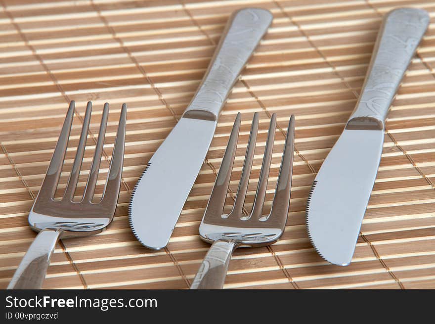 New table fork and knife on bamboo background