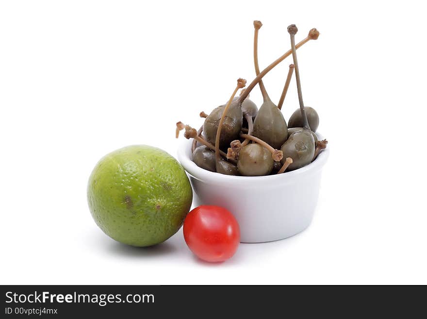 Green freshess lime, cherry tomato in a jam dish. Vegetable and fruits still life isolated on a white background. Green freshess lime, cherry tomato in a jam dish. Vegetable and fruits still life isolated on a white background.