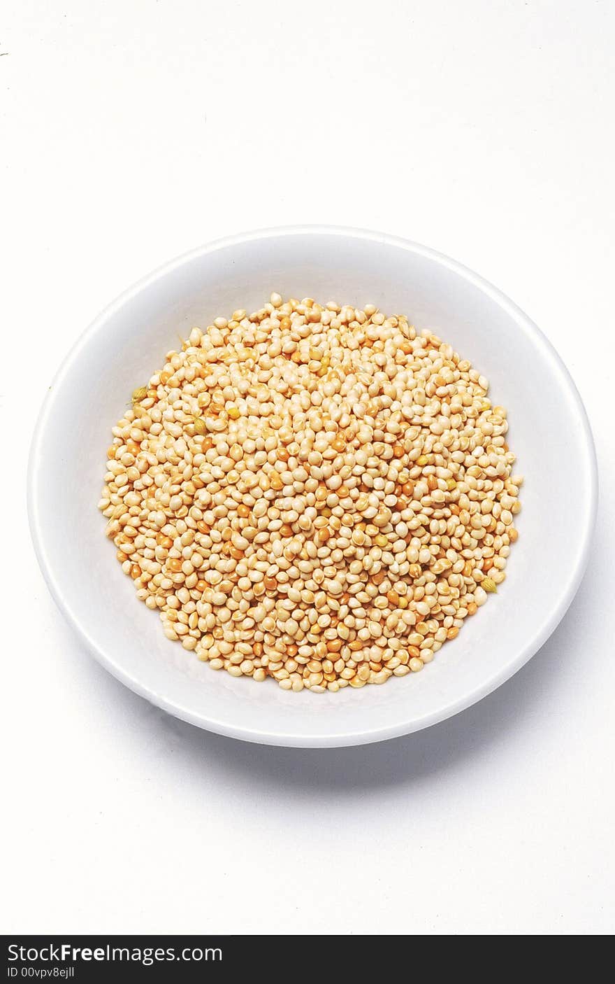 Millet seeds in bowl aginst white background