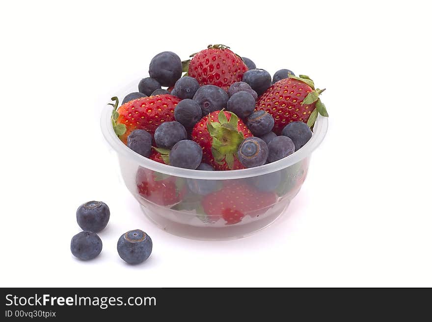 Blueberries and strawberries in a basket on white background