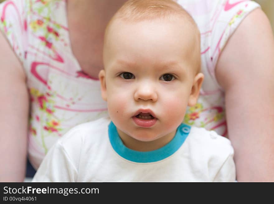 Baby sit down on mother's laps. Face close-up